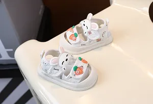 Vue détaillée de sandales blanches pour bébé avec décorations lapin et carotte mignonnes.