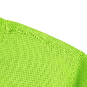 Macro detail of neon green breathable mesh fabric and reinforced shoulder seam.