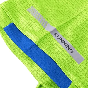 Detail of breathable mesh fabric with reflective RUNNING strip on green T-shirt.