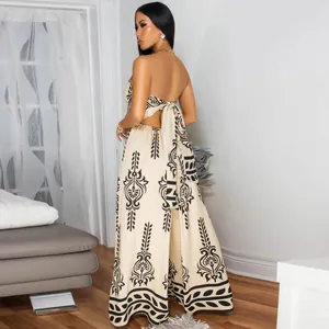 Back view of a beige strapless jumpsuit with black damask print and tie detail.