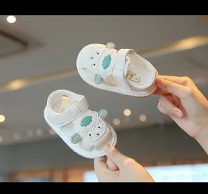 Detailed view of cream-colored infant sandals featuring a cute sheep design and soft soles