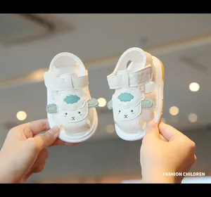 Detail view of white closed-toe baby sandals with cute cartoon sheep design and soft sole