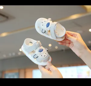 Detailed view of grey baby sandals with a cute cartoon sheep design and soft soles.