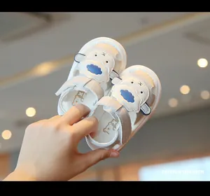 Detailed macro view of white infant sandals featuring a cute cartoon sheep design.
