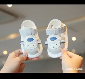 Close-up of soft baby sandals featuring a cute cartoon sheep design and velcro strap