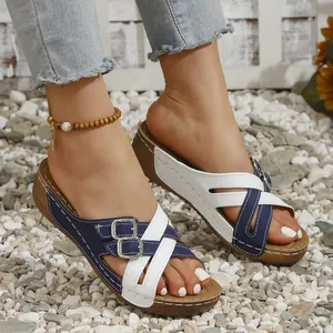 Close-up of stylish wedge sandals with blue and white cross-straps and buckles