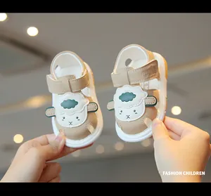Close-up of cute beige baby sandals with cartoon sheep and soft soles