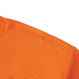 Close-up of orange quick-dry sports t-shirt shoulder seam and grid fabric texture.