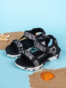 Primer plano detallado de sandalias deportivas de rayas para niños sobre fondo de playa con conchas