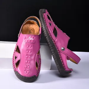 Close-up of fuchsia hollow leather sandals featuring decorative stitching and rubber sole