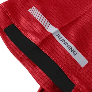 Macro view of red quick-dry grid fabric and reflective strip on a men's running t-shirt