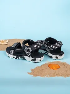 Elegantes sandalias de playa para niños a rayas blancas y negras en un entorno de verano