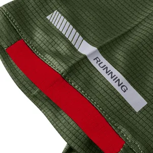 Detail view of green quick-dry sports T-shirt with reflective RUNNING strip on sleeve