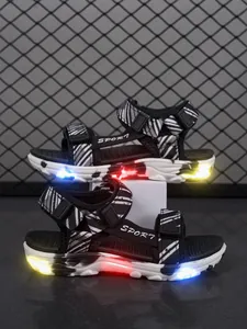 Primer plano de sandalias para niños con luces LED brillantes y diseño de rayas