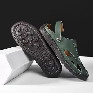 Detailed view of green leather outdoor clogs with a textured non-slip rubber sole.