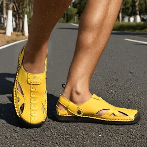 Bright yellow hollow out leather sandals shown on road for outdoor casual beach wear.