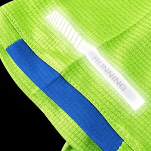 Close-up of white night running reflective strip on lime green quick-dry mesh sports fabric