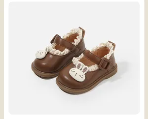 Detailed macro view of brown leather baby walking shoes with lace trim and bunny motif
