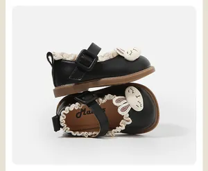 Close-up of black baby Mary Janes with adorable bunny ornament and lace trim