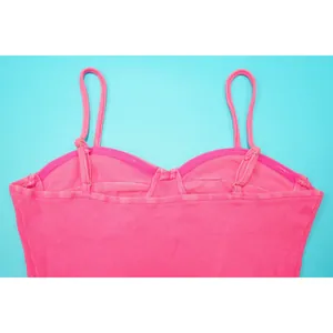Detailweergave van de geribbelde textuur en stiksels van de roze gewassen katoenen top.