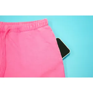 Detail van roze katoenen joggingbroek met smartphone in de zak voor extra opslag
