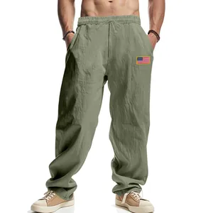 Vue détaillée du pantalon large en lin vert olive pour homme avec écusson drapeau US.
