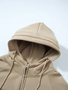 Detail des khakifarbenen Kapuzen-Sweatshirts mit Kordelzug und Metallreißverschluss.