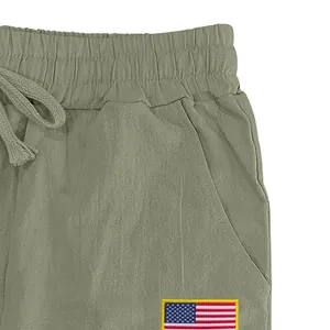 Gros plan d'un pantalon en lin olive avec taille élastique et écusson USA