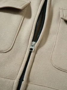 Nahaufnahme des silbernen Metallreißverschlusses und der Stoffstruktur des khakifarbenen Sweatshirts