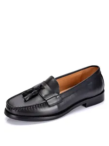 Primo piano di un mocassino classico in pelle nera con nappe e trama in vera pelle