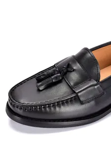 Primo piano dettagliato di mocassini con nappe da uomo in pelle nera con cuciture