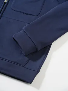 Nahaufnahme eines dunkelblauen Hoodies mit gerippten Bündchen und hochwertiger Taschennaht.