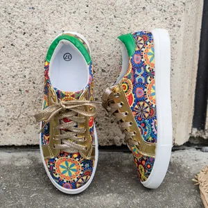 Detail view of vibrant bohemian printed canvas sneakers with sparkling gold laces.