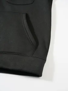 Detailansicht der Tasche und der gerippten Saumnaht eines schwarzen Herren-Hoodies