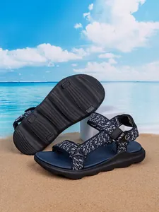 Detail view of boys' blue woven beach sandals with non-slip sole texture