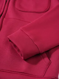 Detailansicht der Manschette und Tasche eines weinroten Kapuzenpullovers für Herren