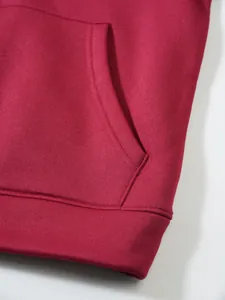 Detailaufnahme eines dunkelroten Kapuzenpullovers mit Taschennaht und Stofftextur.