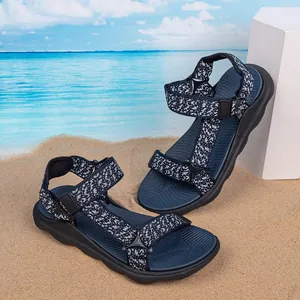 Detail view of blue boy's outdoor beach sandals with patterned straps on sandy background