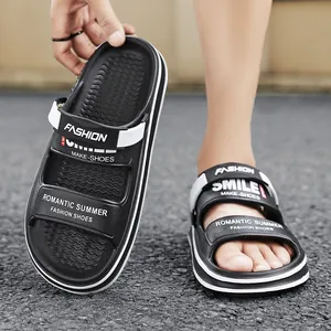 Close-up view of men's black outdoor slippers with white straps and casual text prints