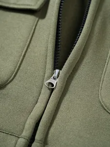 Detailansicht eines Metallreißverschlusses und olivgrüner Strickware für Herren