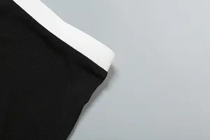 Nahaufnahme des schwarz-weißen Rippstrick-Bunds an schmal geschnittenen Strickshorts.