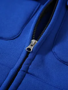 Detailaufnahme eines hochwertigen silbernen Metallreißverschlusses an einer blauen Kapuzenjacke