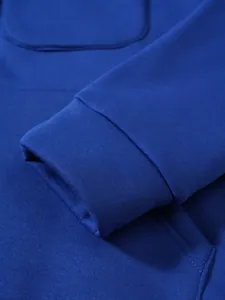 Detailansicht des gerippten Bündchens und der Taschennaht an einem blauen Hoodie-Jacke.