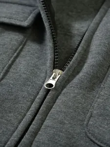 Detailaufnahme eines Metallreißverschlusses und grauen Strickstoffs an einer Herren-Sweatjacke