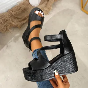 Détail de sandales compensées noires avec semelle plateforme et zip arrière
