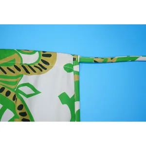 Detailaufnahme eines grünen Sommer-Jumpsuits mit Muster, Nähten und Trägerdesign.