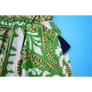 Makroansicht eines grünen Jumpsuits mit Paisleymuster und einer tiefen Seitentasche