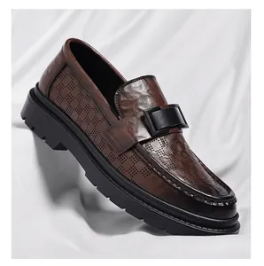 Close-up of brown leather men's loafers featuring laser-cut perforated patterns.