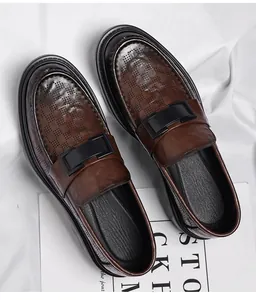 Detailed macro view of brown perforated leather loafers featuring stylish black buckle accents