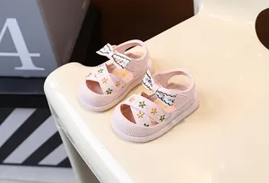 Vue détaillée des sandales roses pour bébé avec broderie florale et nœud mignon.